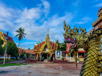 Statue amidst trees and buildings against sky