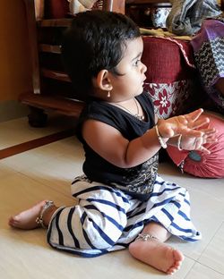 High angle view of baby girl sitting on floor at home