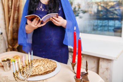 Midsection of woman holding ice cream on table