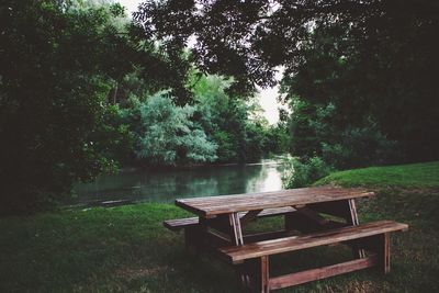 Chair and table by lake in forest