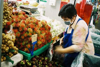 Side view of a man preparing food at market