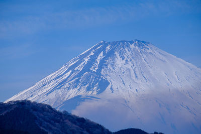 Scenic view of snowcapped mountain against blue sky