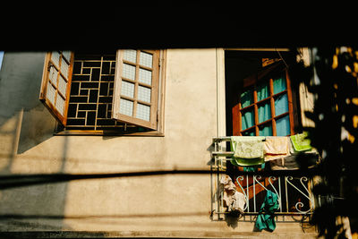 Chairs and table by window on wall of building