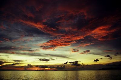 Scenic view of sea against cloudy sky at sunset