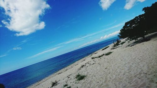 Scenic view of beach against blue sky