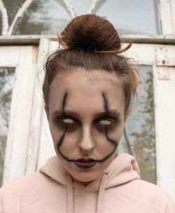 Close-up of blind girl with halloween make-up against building