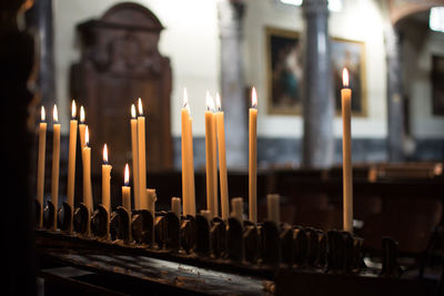 Burning candles in temple against building