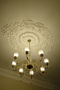 Low angle view of illuminated pendant lights hanging from ceiling