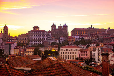 Buildings in city against sky during sunset