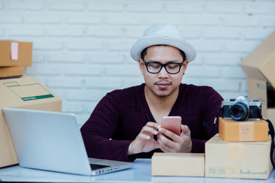 Portrait of mature man using smart phone on table