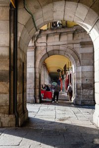 Rear view of people walking in corridor of building