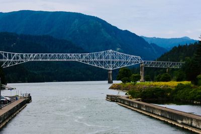 Bridge over river against mountains