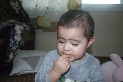 Portrait of cute boy eating food at home
