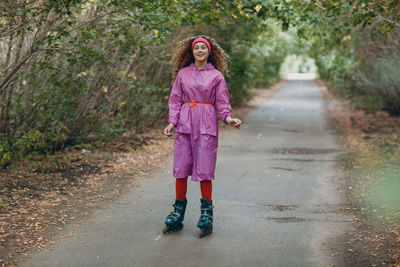 Full length portrait of girl standing on pink umbrella