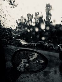 Close-up of wet car on road against sky