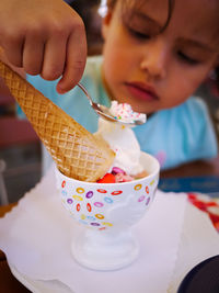 Midsection of boy holding ice cream on table