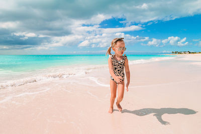 Full length of woman on beach against sky