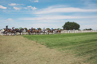 Panoramic view of people on field against sky