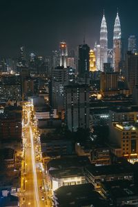 Illuminated cityscape against sky at night