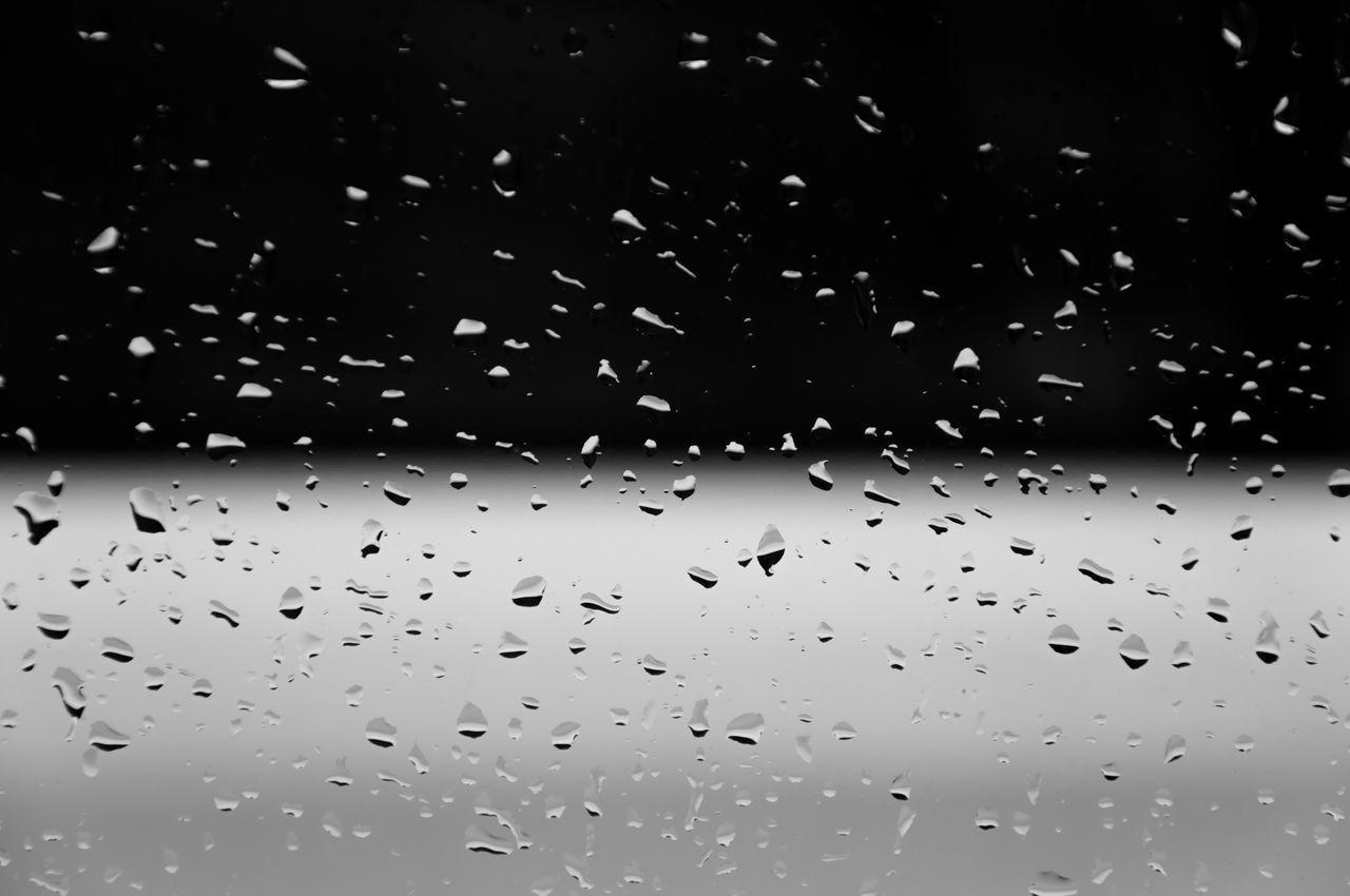 FULL FRAME SHOT OF WET GLASS WINDOW DURING MONSOON