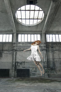 Woman standing mid air against the wall