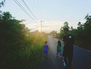 Rear view of couple walking against plants