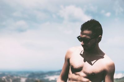 Young man standing in sea against sky