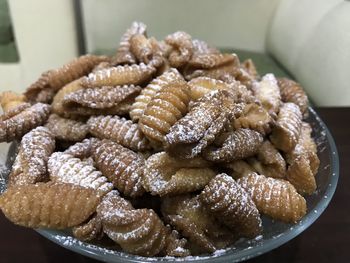 Kulkul is made from maida flour, milk and shaped into small shells and fried in ghee or oil.