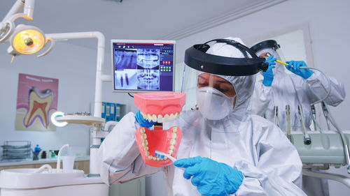 High angle view of female doctor examining dentures