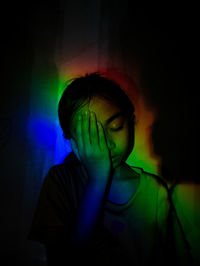 Portrait of boy in illuminated dark room