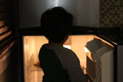 Boy standing by refrigerator at home
