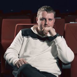 Young man sitting on chair in cinema theatre