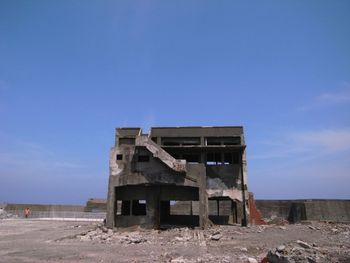 Abandoned building on field against sky