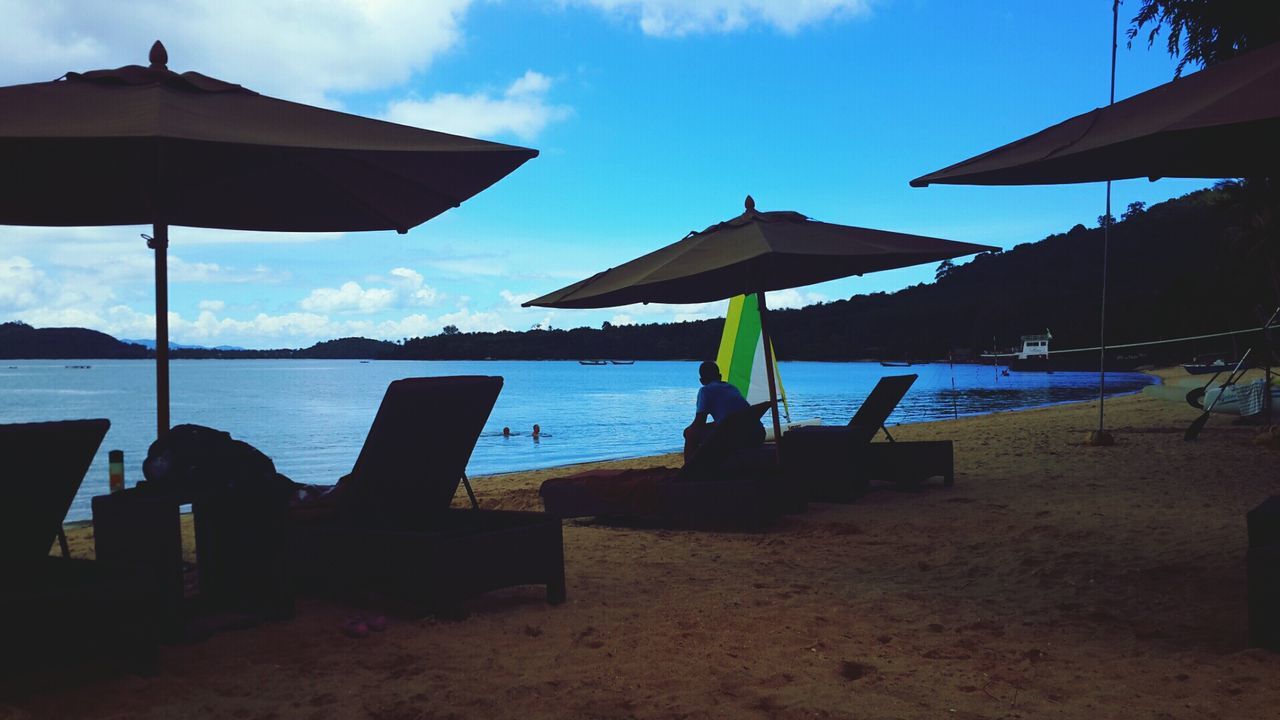 sea, sky, beach, water, horizon over water, chair, lounge chair, absence, table, sand, sunlight, shore, parasol, built structure, tranquil scene, tranquility, beach umbrella, cloud - sky, sunshade, scenics