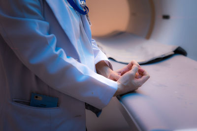 Midsection of doctor standing by bed in hospital