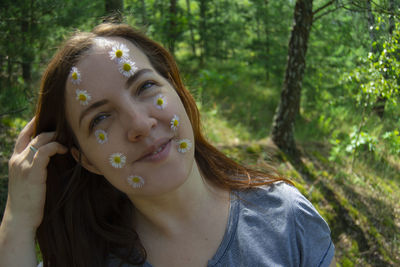 Close-up portrait of a young woman in forest