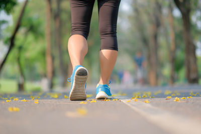 Rear view of woman walking on road