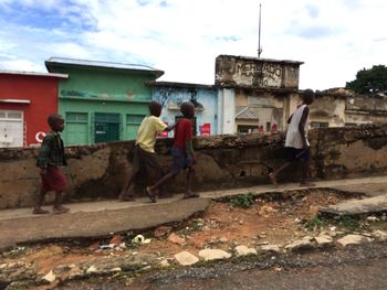 People on street in city against sky