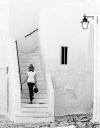 Rear view of woman moving up on steps