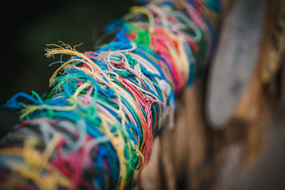 Close-up of multi colored threads tied on railing