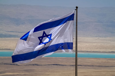 Scenic view of flag on road against sky