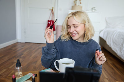 Young woman using mobile phone at home