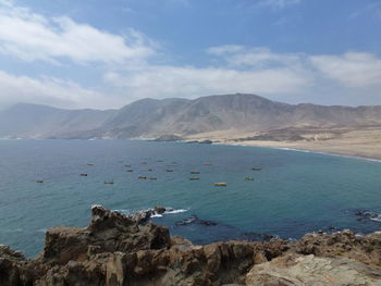 Scenic view of sea and mountains against sky