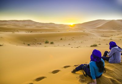 Tourists looking at sunset in desert