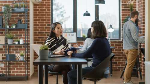 Portrait of woman using laptop while sitting on table