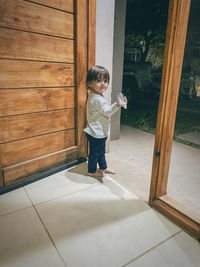 Full length of young man standing against wall