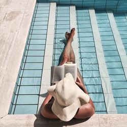 Low section of man relaxing in swimming pool