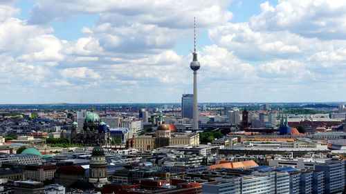 Modern buildings in city against cloudy sky