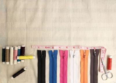 Close-up of multi colored zipper and spools on table