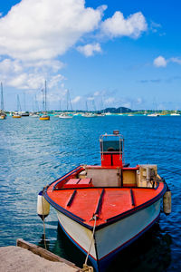 Sailboats moored on sea against sky